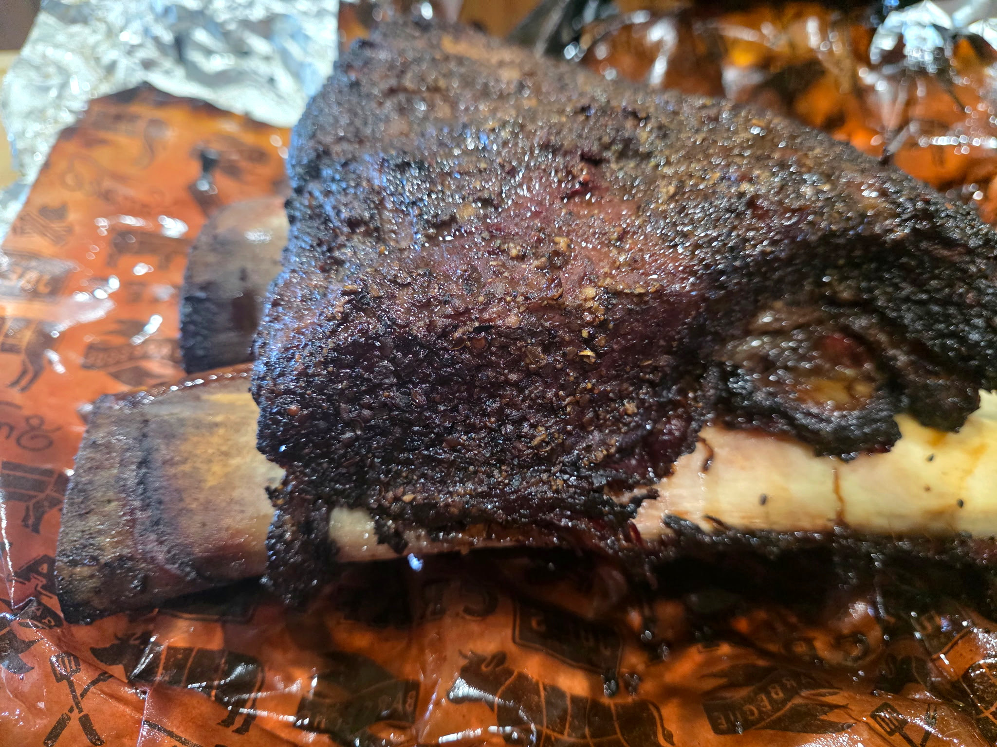 Smoked beef ribs with a dark crust and large rib bones, photographed at Red Cooler BBQ.