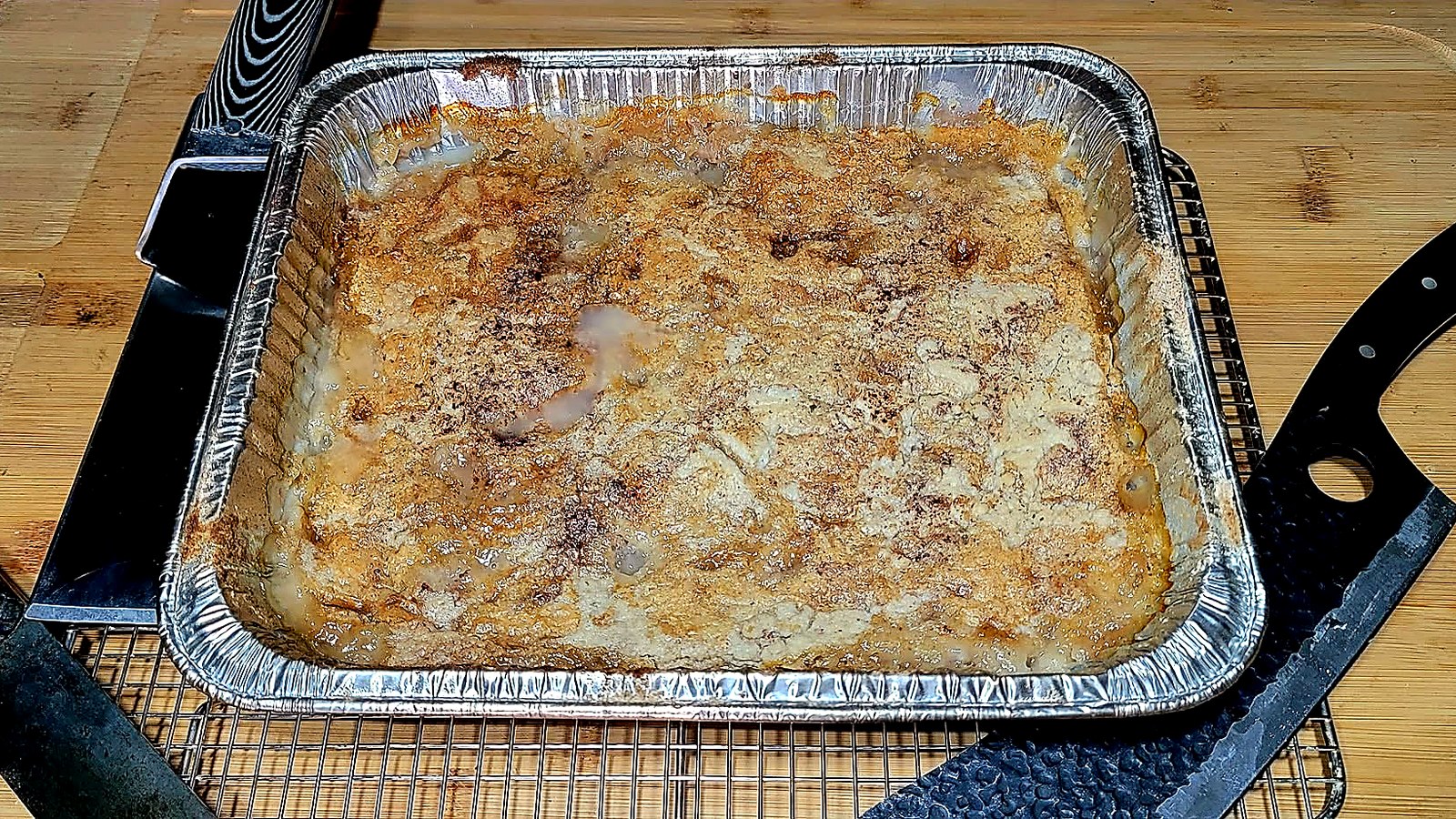 Pan of homemade smoked peach cobbler with a golden crust.